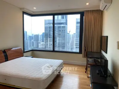 Spacious bedroom with stunning city view in modern high-rise apartment.