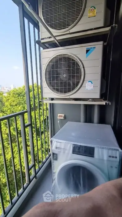 Modern balcony with air conditioning units and washing machine, city view