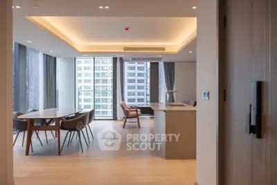 Modern open-plan living and dining area with city view, featuring sleek furniture and contemporary design.