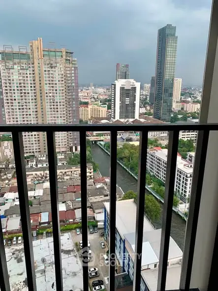 Stunning cityscape view from a high-rise balcony overlooking urban skyline and river.