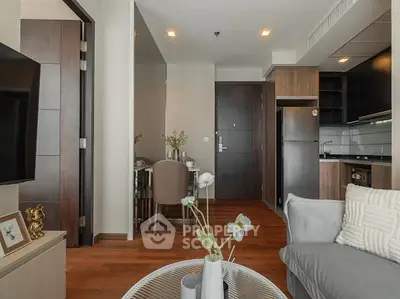 Modern apartment interior with open kitchen and cozy living area, featuring elegant decor and wooden flooring.