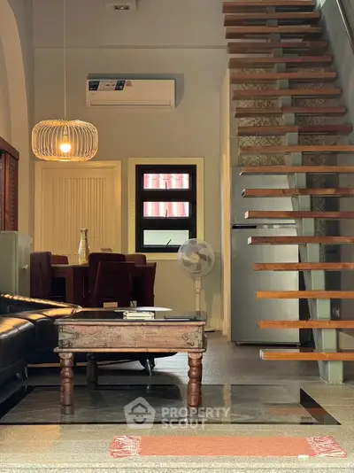 Stylish living room with modern staircase and cozy dining area