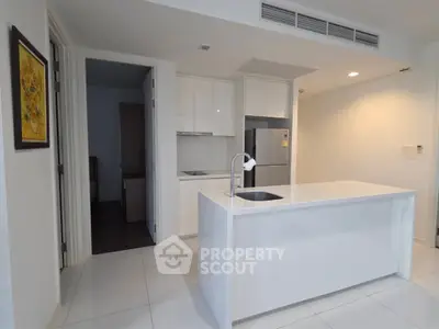 Modern kitchen with sleek white cabinetry and island in contemporary apartment