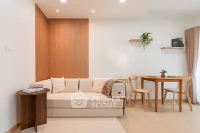 Modern living room with cozy sofa and dining area, featuring elegant wooden accents and soft lighting.