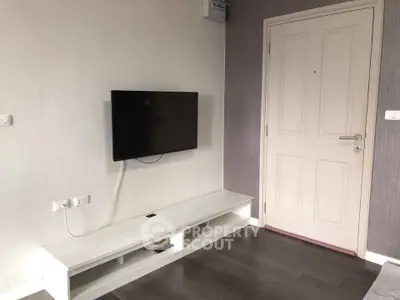 Modern living room with wall-mounted TV and sleek white console