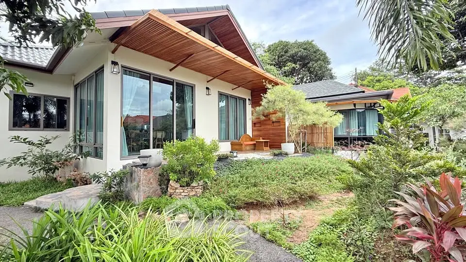 Charming modern house with lush garden and large windows, perfect for nature lovers.