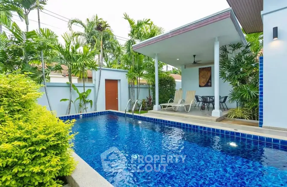 Luxurious private pool area with lush greenery and modern patio, perfect for relaxation and entertainment.