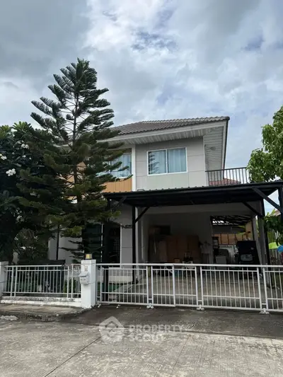 Charming two-story house with spacious driveway and lush greenery, perfect for family living.