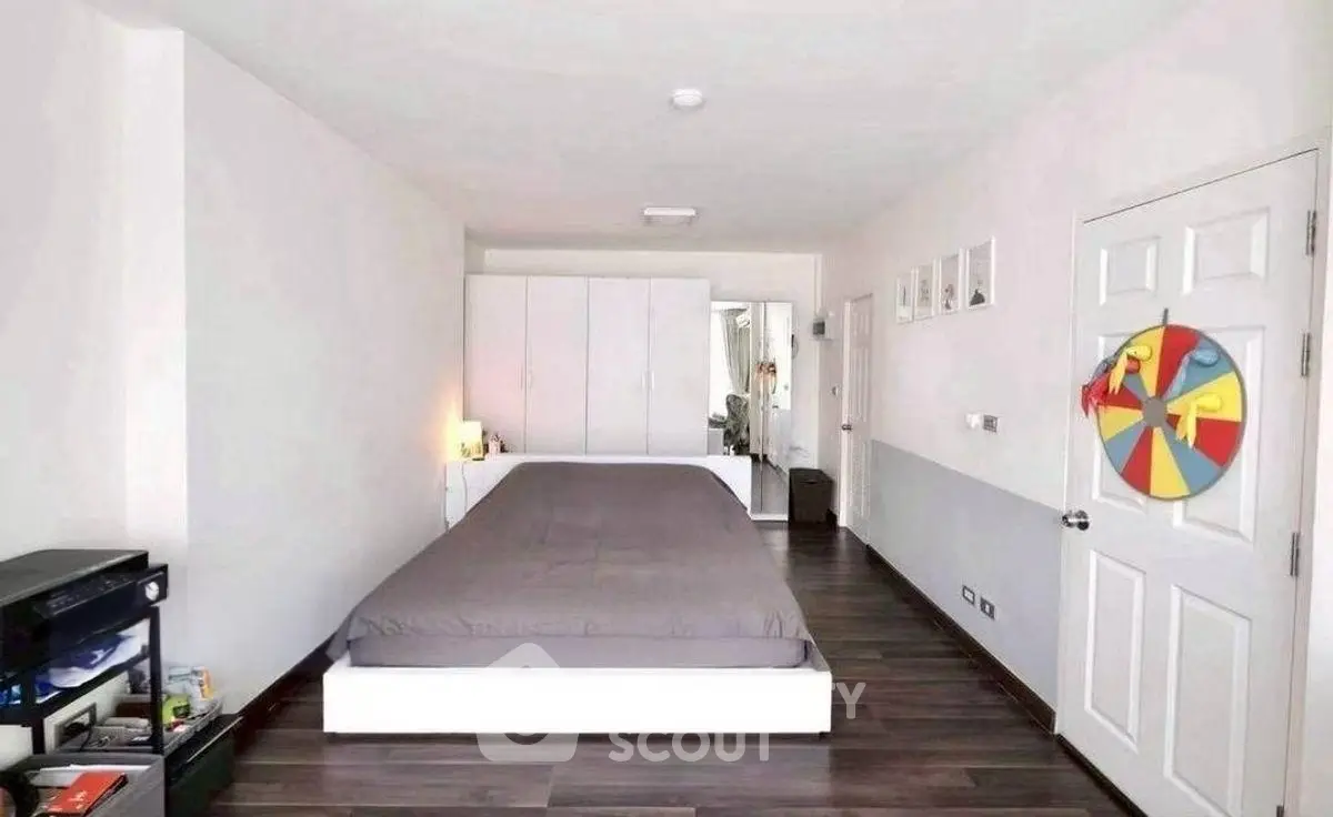 Spacious modern bedroom with sleek wooden flooring and minimalist decor