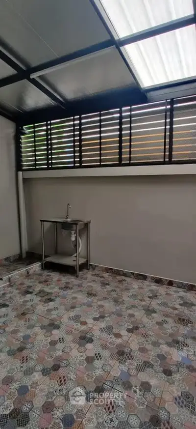 Spacious tiled area with modern sink and ample natural light