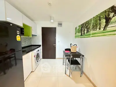 Modern kitchen with sleek appliances and dining area, featuring a washing machine and stylish decor.