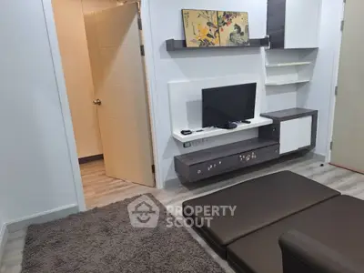 Modern living room with sleek furniture and wall-mounted TV in a cozy apartment.