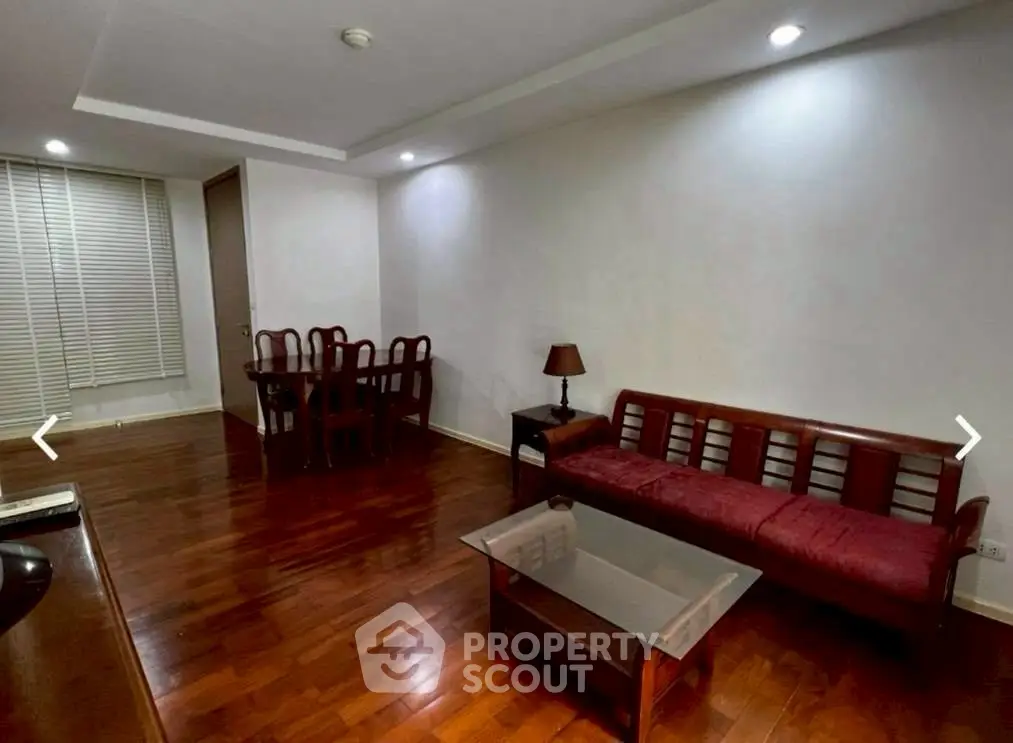 Spacious living room with wooden flooring and elegant furniture in modern apartment.