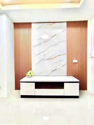 Modern minimalist living room with elegant marble accent wall and sleek furniture.