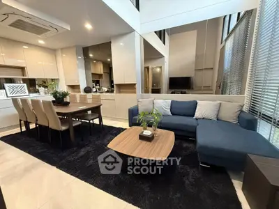 Modern living room with open kitchen, stylish furniture, and elegant decor