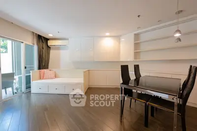 Modern living room with sleek dining area and built-in storage, featuring elegant wood flooring and natural light.