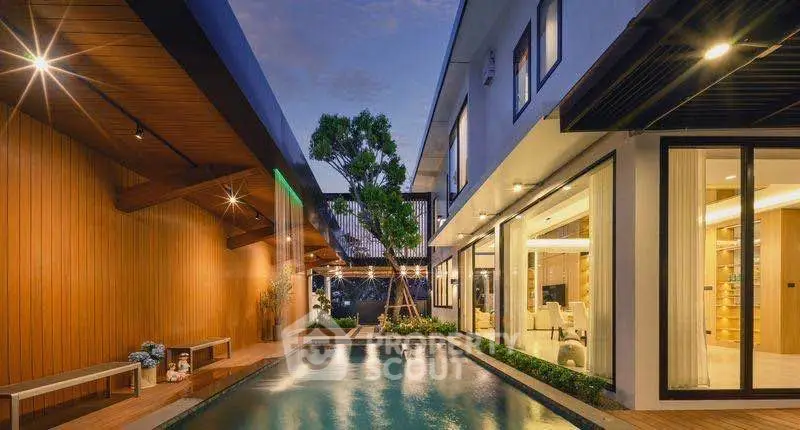 Luxurious modern home with stunning pool and elegant lighting at dusk.