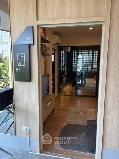 Modern one-bedroom apartment entrance with stylish interior design and wooden flooring.