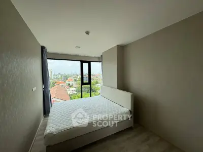 Spacious bedroom with panoramic city view and modern minimalist design.