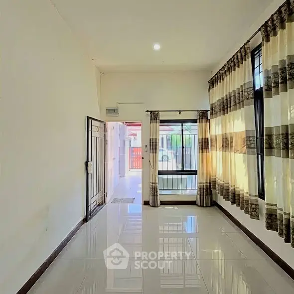 Bright and airy living room with large windows and tiled flooring, perfect for natural light lovers.