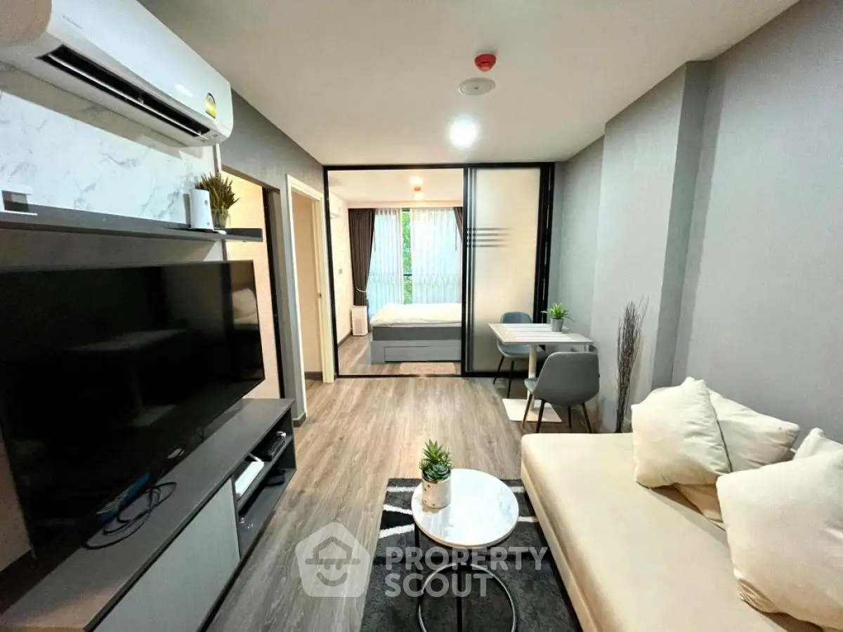 Modern apartment living room with stylish decor and open view to bedroom