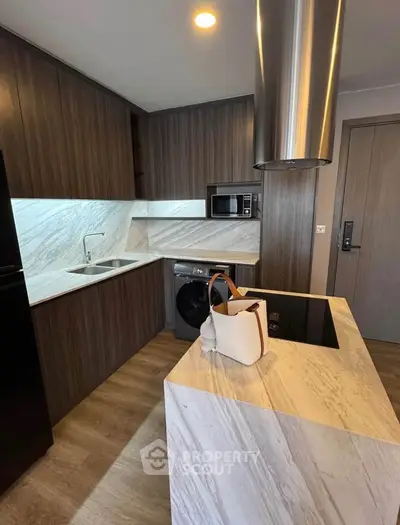 Modern kitchen with sleek wooden cabinets, marble countertops, and built-in appliances in a stylish apartment.