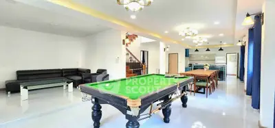 Spacious living room with pool table and modern kitchen in open layout