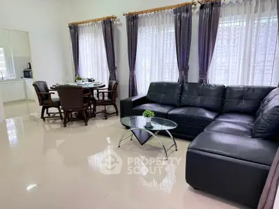 Spacious living room with elegant dining area and modern furniture, perfect for family gatherings.