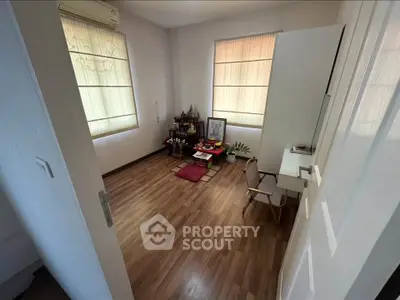 Cozy study room with wooden flooring and natural light, perfect for productivity and relaxation.