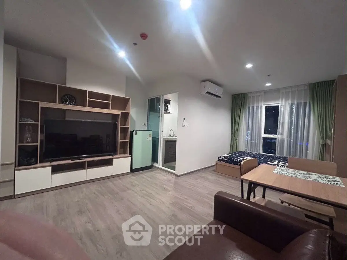 Modern living room with open layout, featuring stylish furniture and large TV unit, perfect for relaxation.