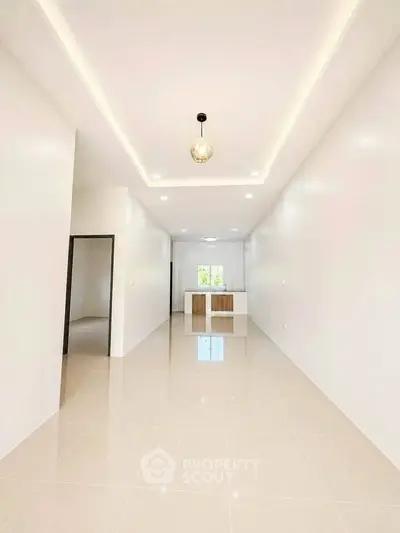 Spacious modern interior with sleek kitchen and elegant lighting, perfect for contemporary living.