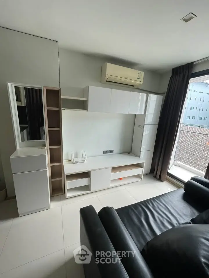 Modern living room with sleek furniture and balcony access in urban apartment