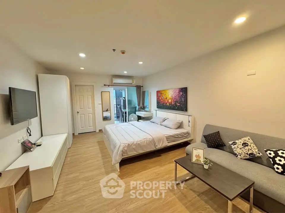 Spacious modern bedroom with cozy seating area and stylish decor