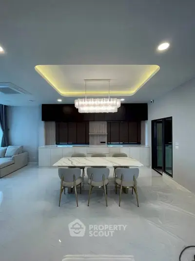 Modern dining area with elegant lighting and sleek furniture in a contemporary home.