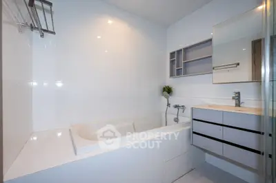 Modern bathroom with sleek white tiles and built-in bathtub