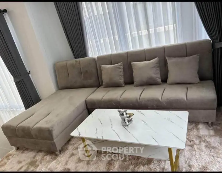 Modern living room with plush gray sofa and elegant marble coffee table.