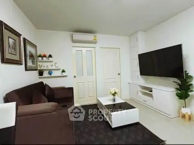 Modern living room with sleek furniture and large TV, perfect for relaxation and entertainment.