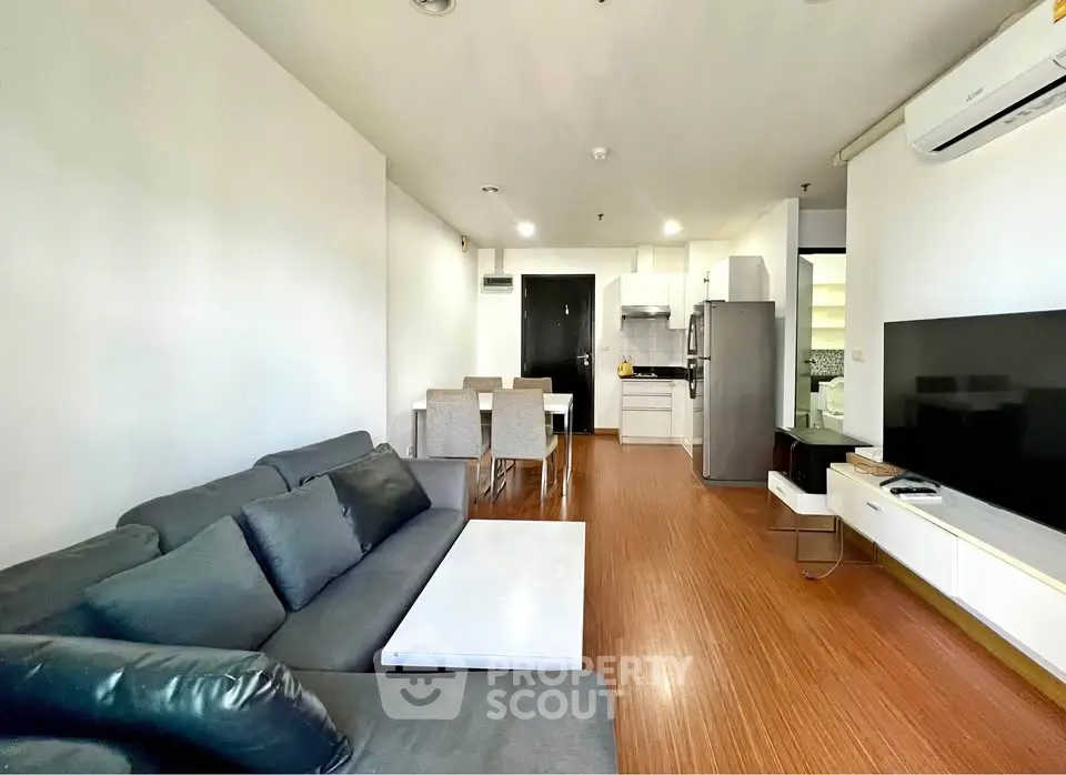 Modern living room with sleek furniture and open kitchen layout in a stylish apartment.