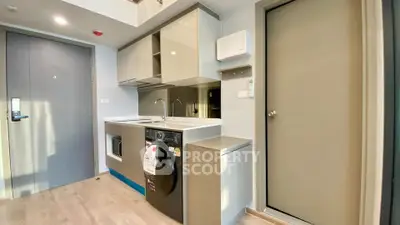 Modern compact kitchen with integrated washing machine and sleek cabinetry