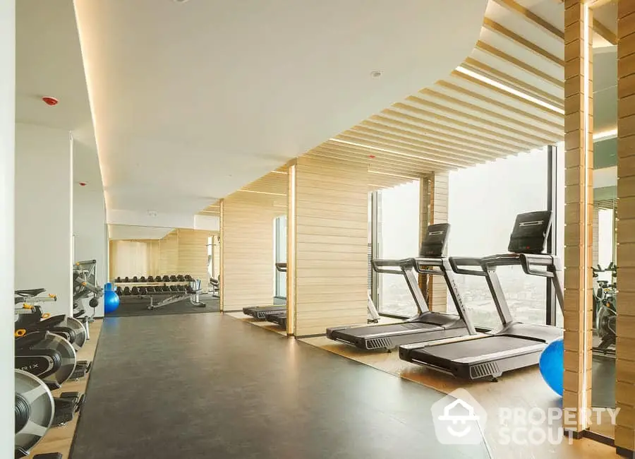 Modern gym with treadmills and exercise equipment in luxury high-rise building.