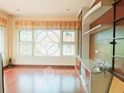 Spacious living room with large windows and built-in shelving, perfect for modern living.