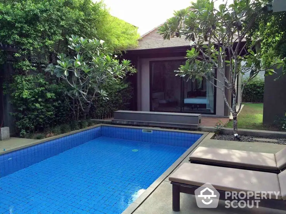 Charming backyard with a serene pool and lush greenery, perfect for relaxation and outdoor enjoyment.