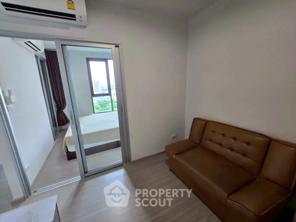 Modern apartment with cozy living room and bedroom view, featuring sleek air conditioning and stylish furniture.