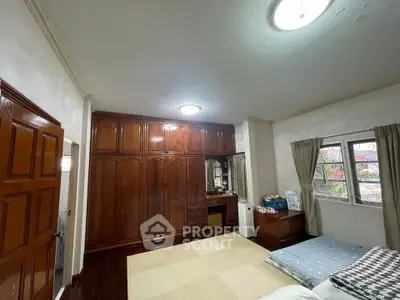 Spacious bedroom with wooden wardrobe and large window view