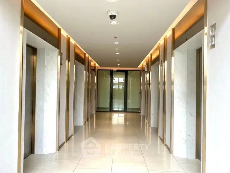 Modern building corridor with multiple elevators and sleek design.