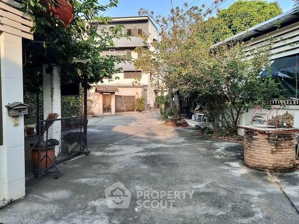 Spacious outdoor area with trees and a multi-story building, perfect for relaxation.