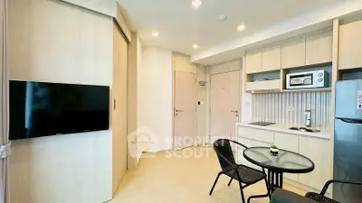 Modern kitchen with open layout, featuring sleek appliances and cozy dining area.