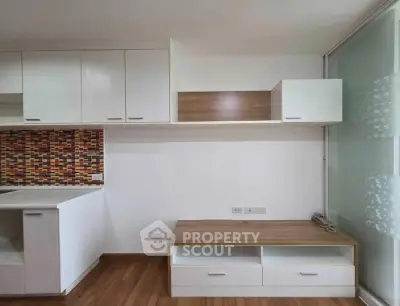 Modern kitchen with stylish cabinetry and colorful backsplash in a cozy apartment.