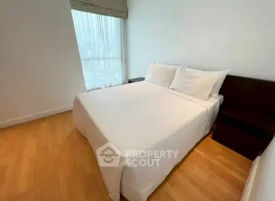 Cozy bedroom with large window and wooden flooring