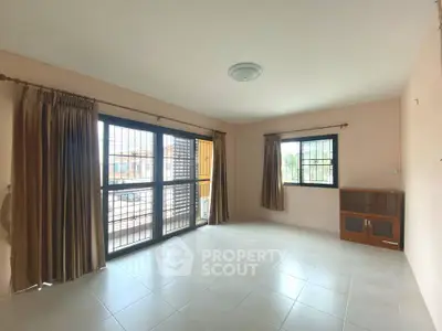 Spacious living room with large windows and natural light in modern apartment.